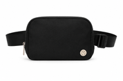 A black nylon waist bag with an adjustable black webbing strap and a small circular silver-tone metal emblem on the front, shown against a plain white background.