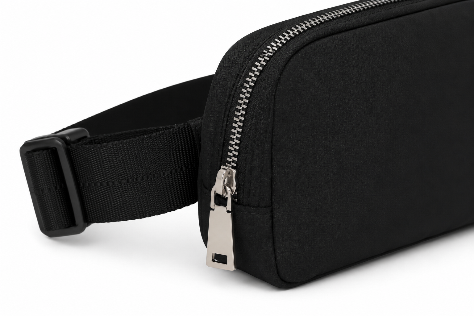 A close-up of a black nylon waist bag with an adjustable black webbing strap and silver metal zipper hardware, shown on a white background.