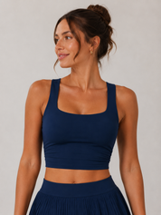 Woman wearing a navy blue sports bra and leggings against a plain background