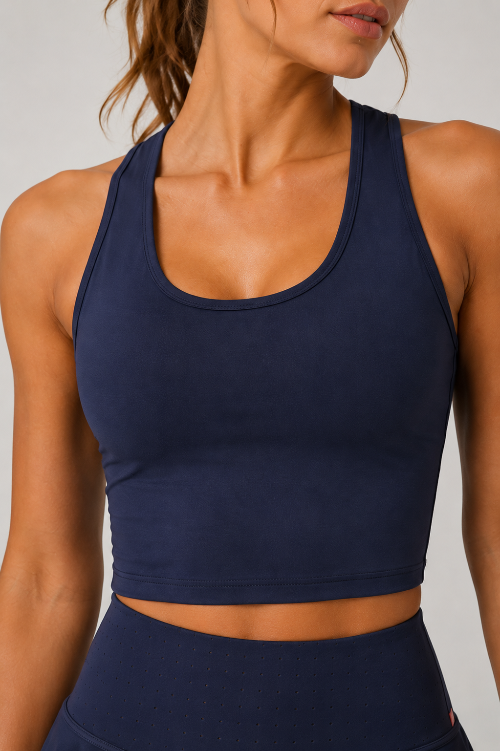 Navy blue sports bra worn by a person on a neutral background