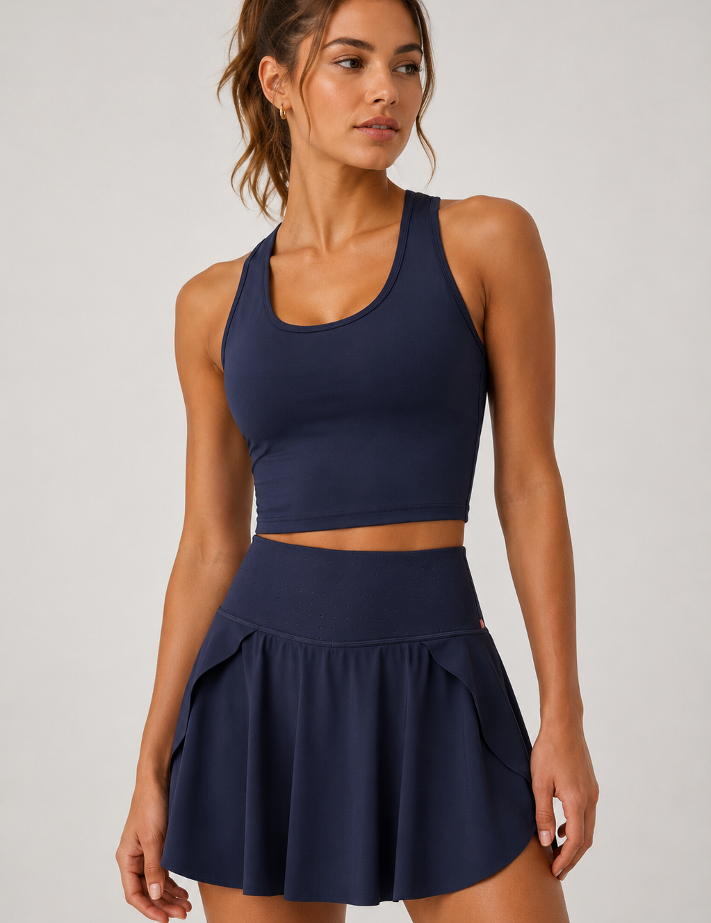 Woman wearing a navy blue athletic outfit on a light gray background