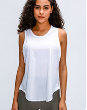 Woman wearing a white sleeveless top with a plain background