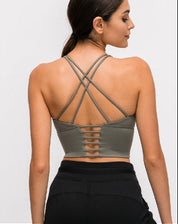 Woman wearing a green sports bra and black pants, shown from front and back on a white background.