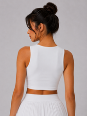 Woman wearing a white sleeveless top and skirt set on a plain background