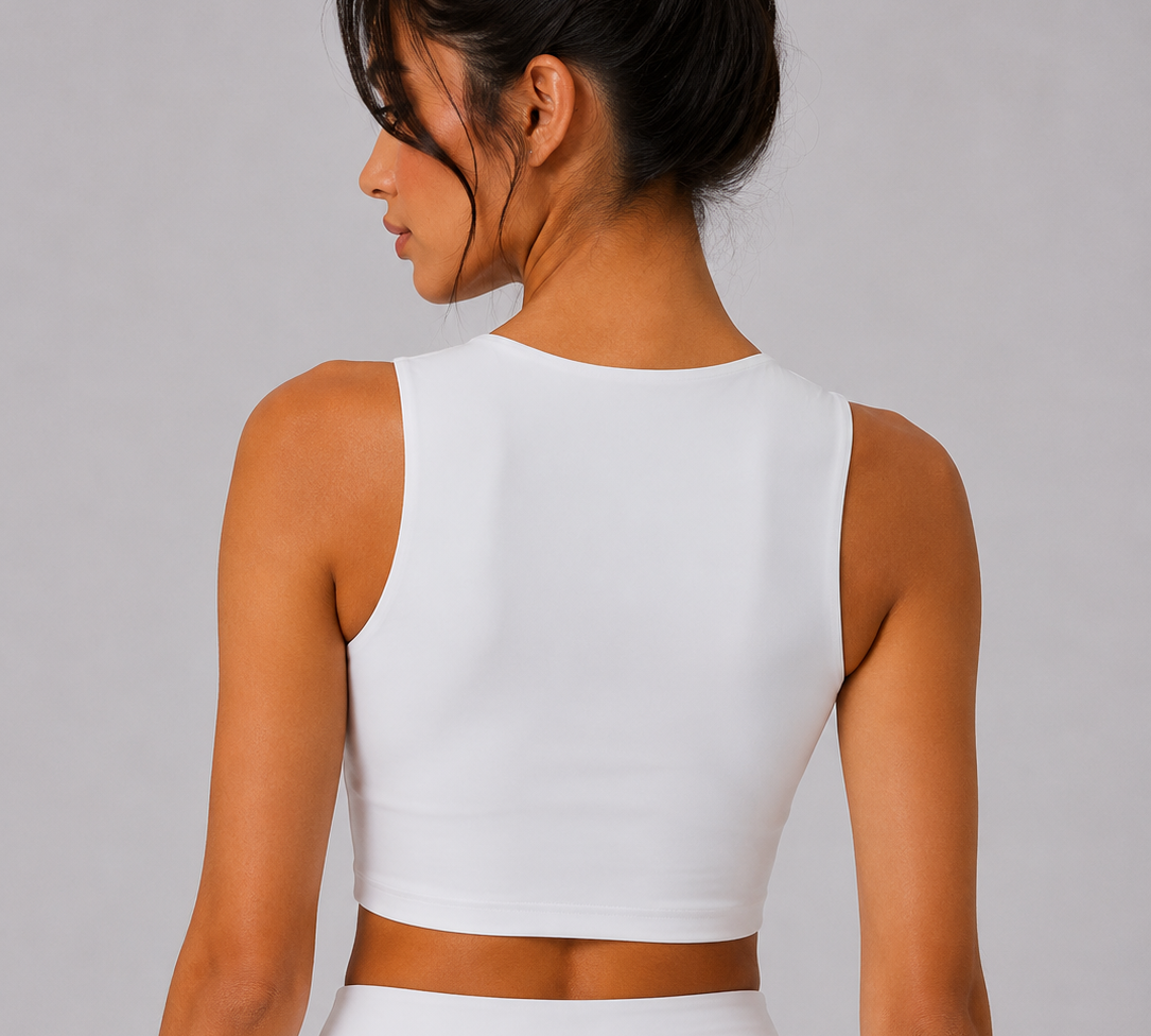 Woman wearing a white sleeveless top and skirt set on a plain background