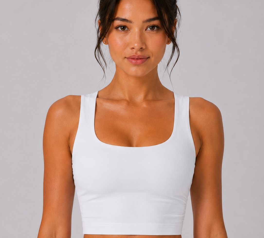 Woman wearing a white tank top against a gray background